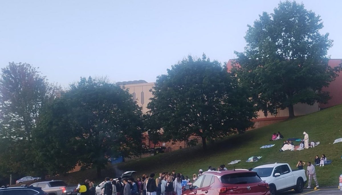 Everyone gathering on blankets, eating breakfast, and watching the sunrise from high atop a hill in Akron.